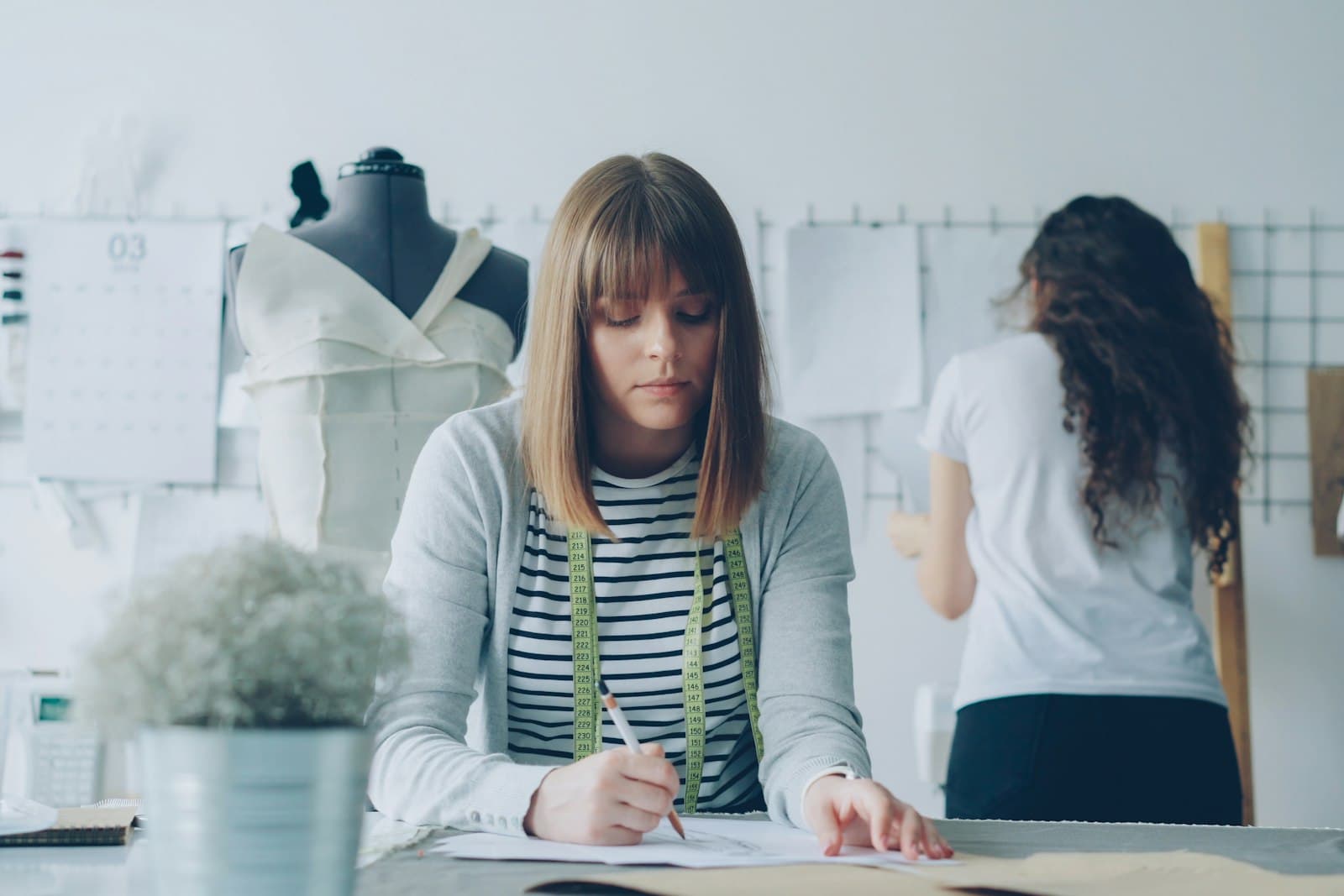Zwei junge Frauen arbeiten in einer Werkstatt an Entwürfen